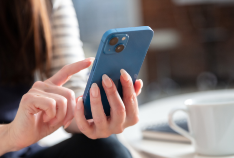 Femme consultant Instagram sur son téléphone pour vérifier les formats visuels de ses publications