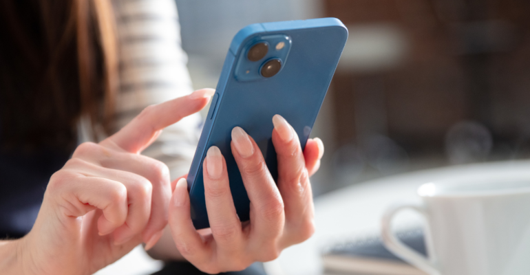 Femme consultant Instagram sur son téléphone pour vérifier les formats visuels de ses publications